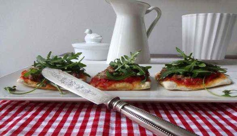 Vegane Pizza mit Haselnuss-Topping und Rucola